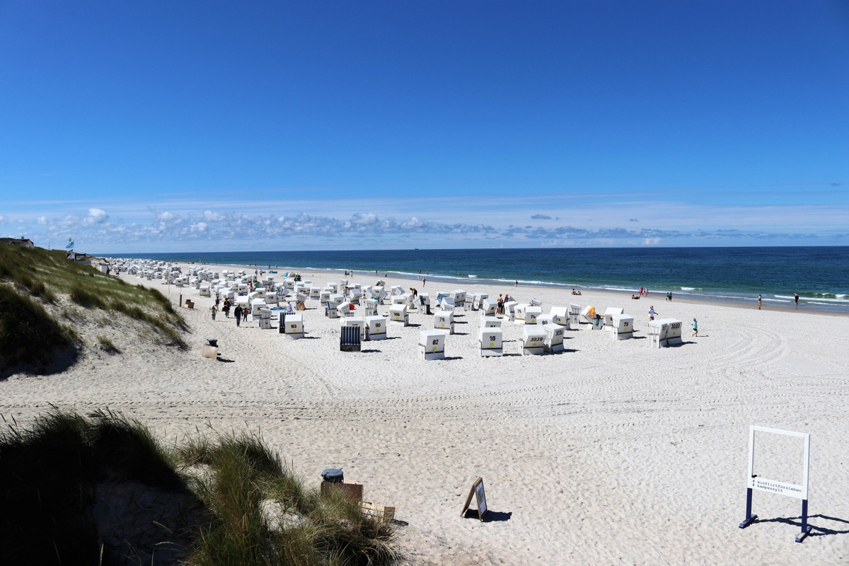 Breiter Sandstrand auf Sylt mit Strandkörben bei Sonnenschein