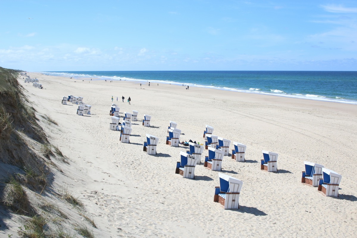 Strandkörbe am breiten Sandstrand auf Sylt mit Dünen