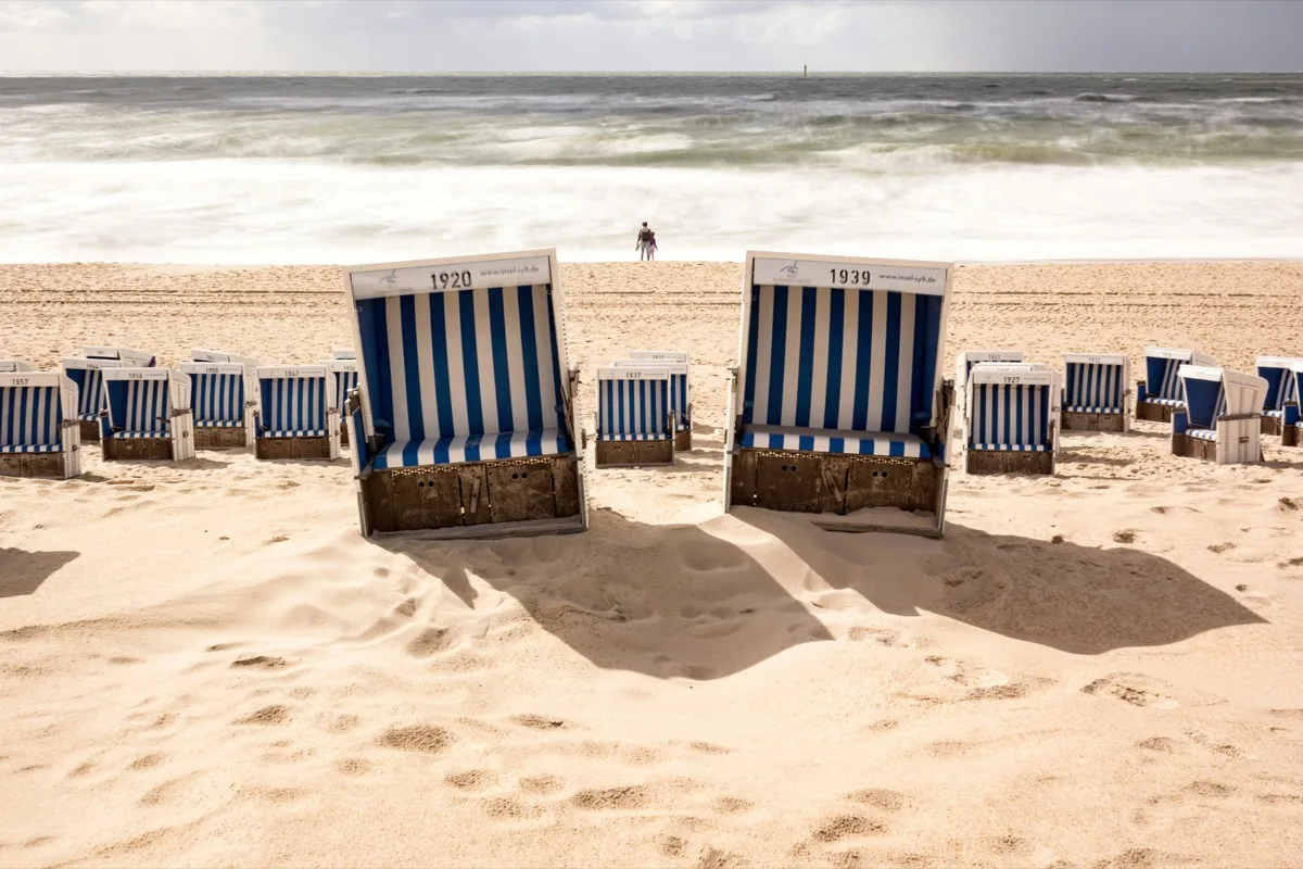 Blau-weiß gestreifte Strandkörbe am Strand von Westerland auf Sylt